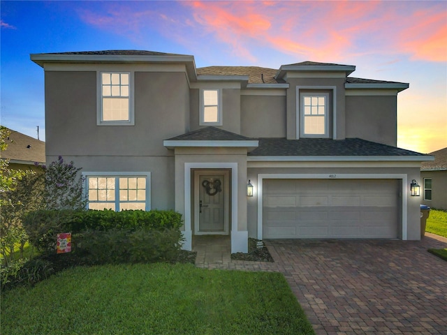 view of front of house with a garage and a lawn