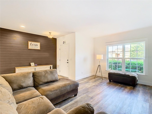 living room with hardwood / wood-style flooring and wood walls