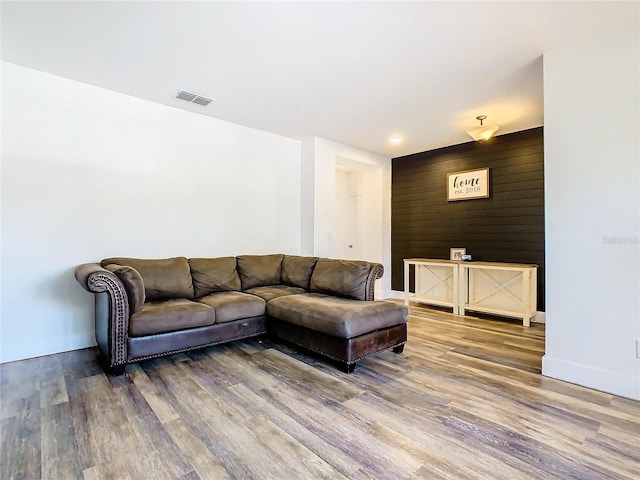 living room with wooden walls and hardwood / wood-style flooring