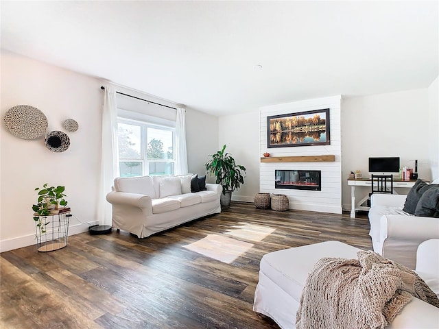 living room featuring dark wood-type flooring and a large fireplace