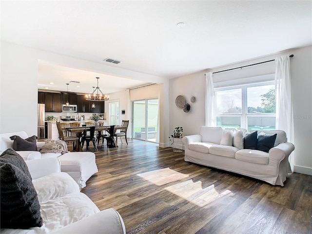 living room featuring dark hardwood / wood-style flooring and a chandelier