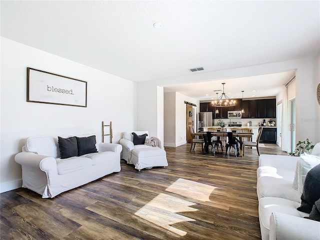 living room with an inviting chandelier and dark wood-type flooring