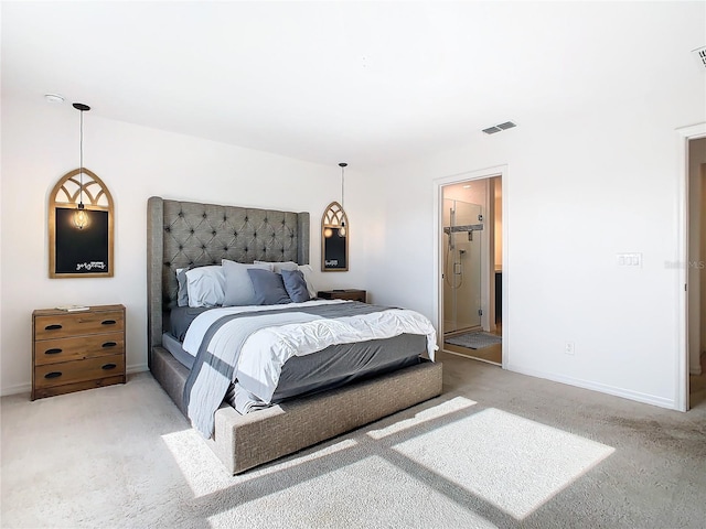 bedroom with ensuite bath and light colored carpet