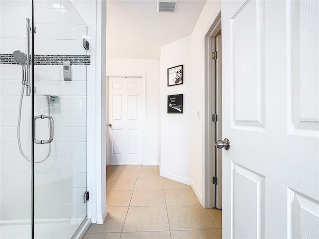 bathroom with tile patterned floors and a shower with shower door