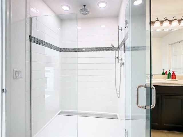 bathroom with walk in shower, vanity, and tile patterned floors