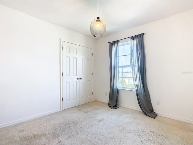 unfurnished bedroom with light carpet and a closet