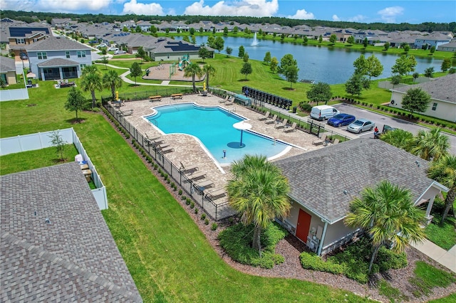 view of pool with a patio, a lawn, and a water view