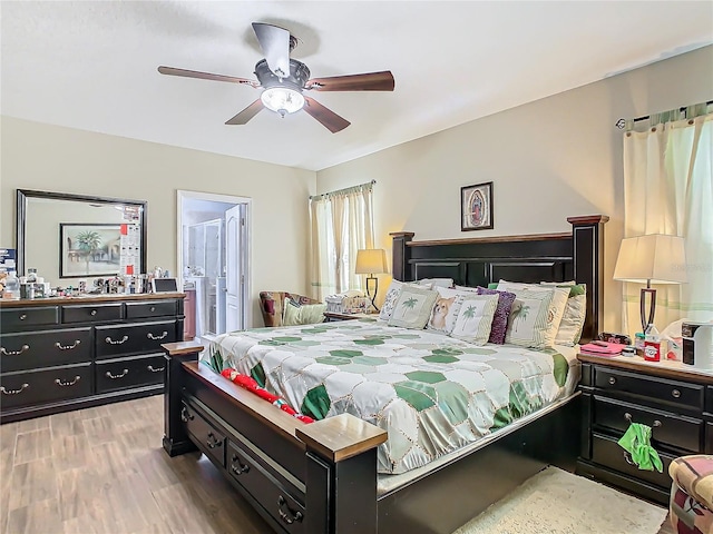 bedroom featuring connected bathroom, ceiling fan, and wood-type flooring