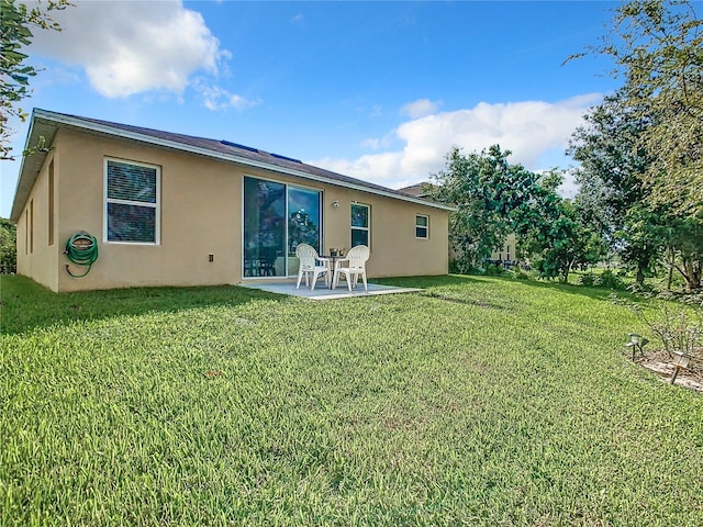 rear view of house with a lawn and a patio area