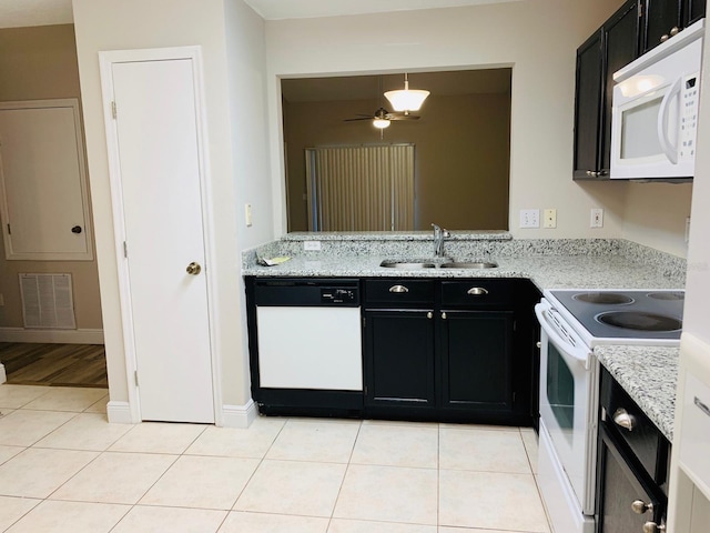 kitchen with sink, light stone countertops, light tile patterned floors, white appliances, and ceiling fan