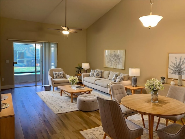 living room with hardwood / wood-style floors, high vaulted ceiling, and ceiling fan