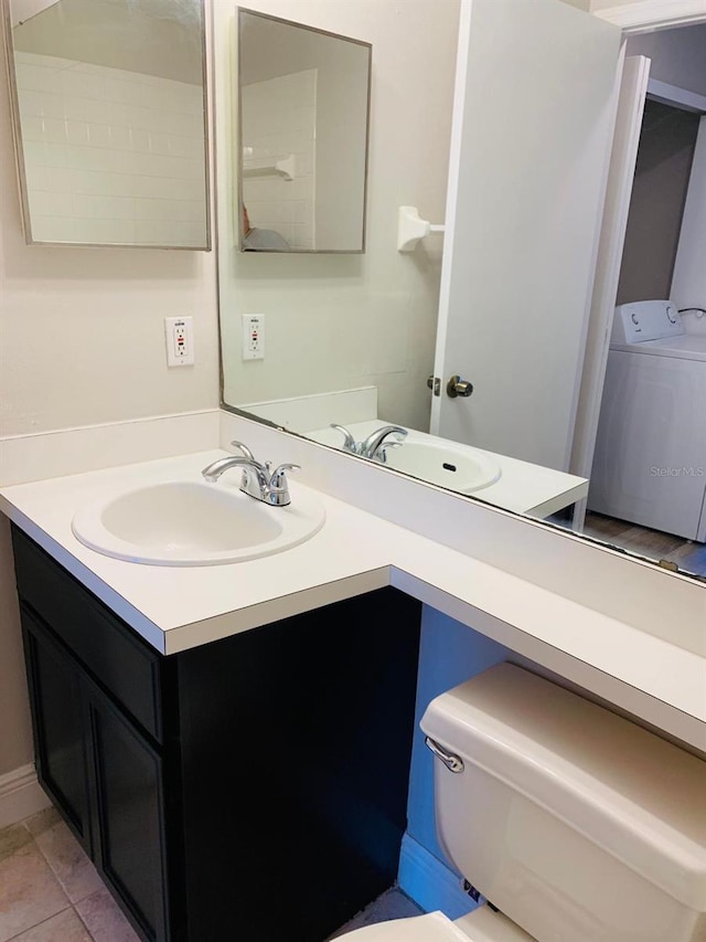 bathroom with toilet, washer / clothes dryer, vanity, and tile patterned flooring