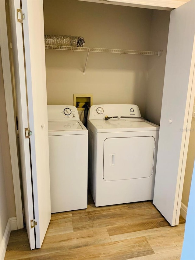 laundry room featuring washing machine and dryer and light wood-type flooring