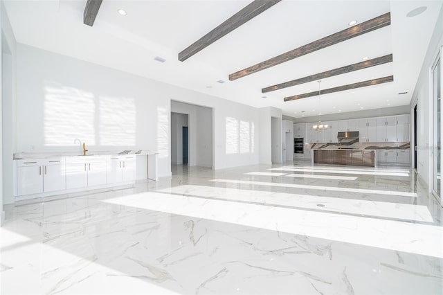 unfurnished living room featuring beam ceiling