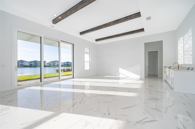 spare room featuring beamed ceiling and a water view