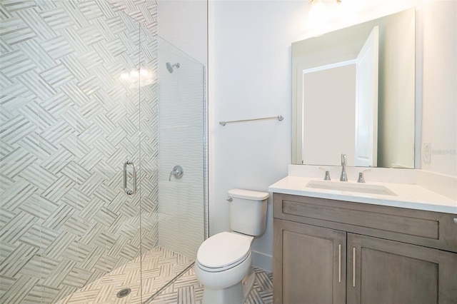 bathroom with vanity, a shower with door, and toilet