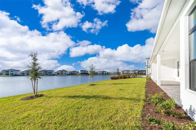 view of yard with a water view and a patio