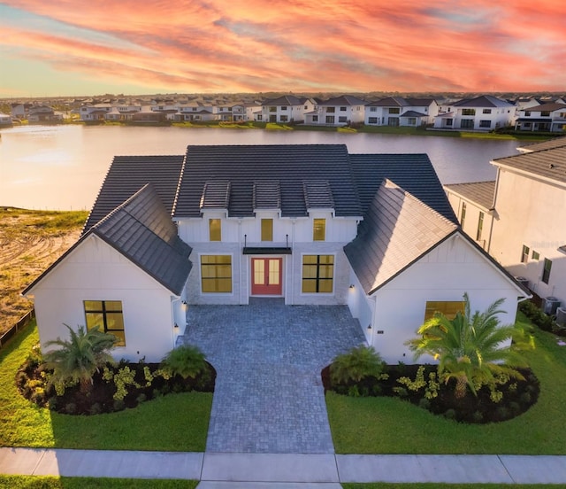 view of front of home with a water view and a yard