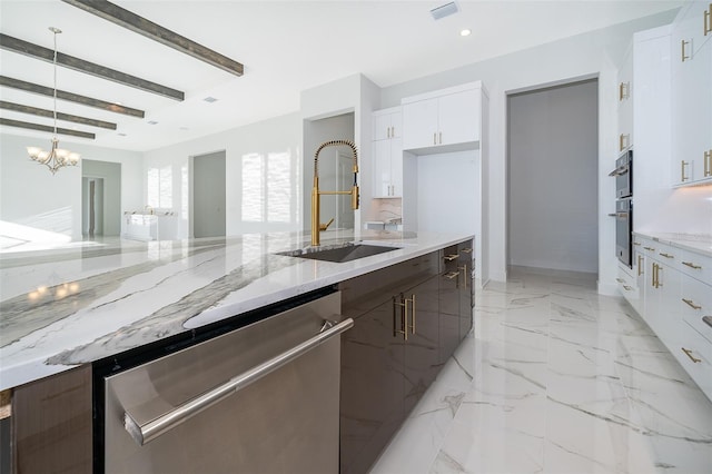 kitchen with light stone counters, stainless steel appliances, hanging light fixtures, and white cabinetry