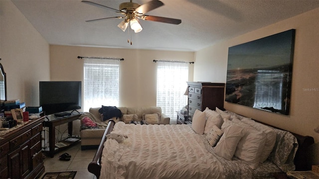 tiled bedroom featuring a textured ceiling and ceiling fan