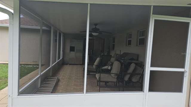 sunroom featuring ceiling fan