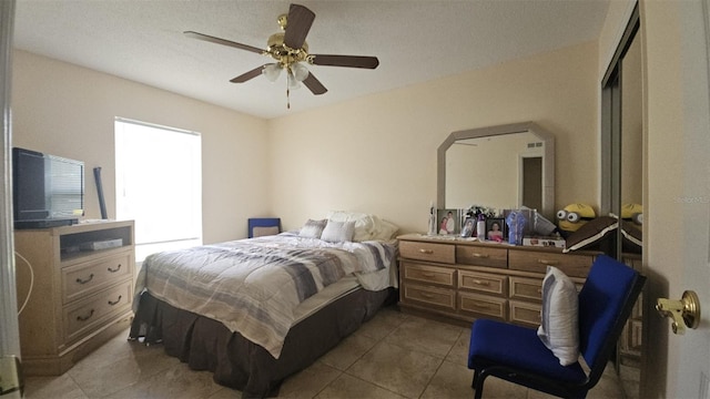 bedroom with ceiling fan and tile patterned floors