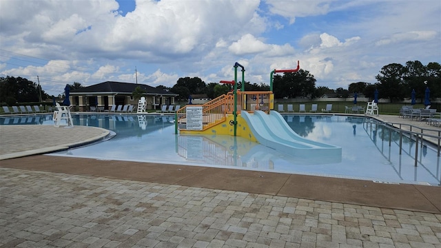 view of swimming pool featuring a playground and a patio area