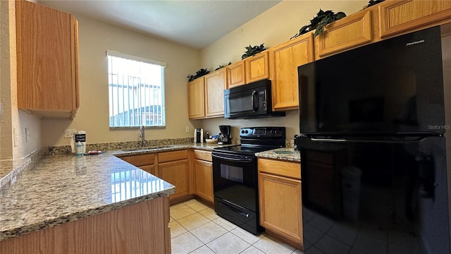 kitchen featuring black appliances, sink, light tile patterned floors, and stone countertops