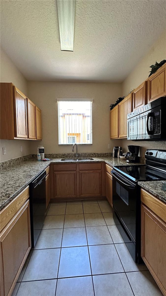 kitchen with black appliances, a textured ceiling, light tile patterned floors, and sink