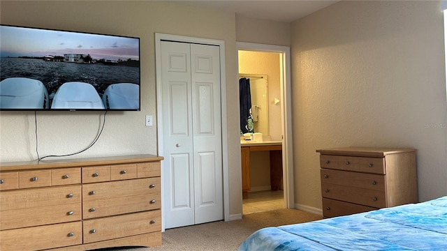 bedroom featuring light carpet, ensuite bath, and a closet