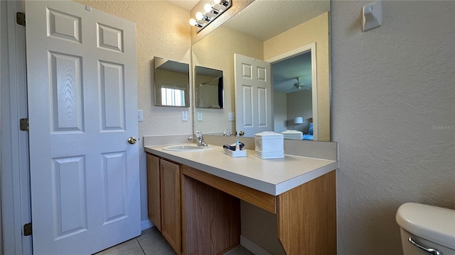 bathroom featuring ceiling fan, vanity, toilet, and tile patterned floors