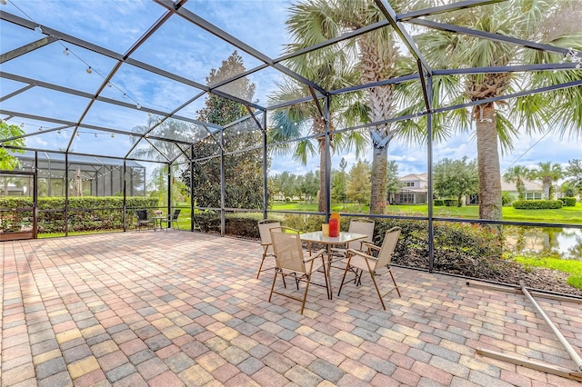 view of patio with a water view and a lanai