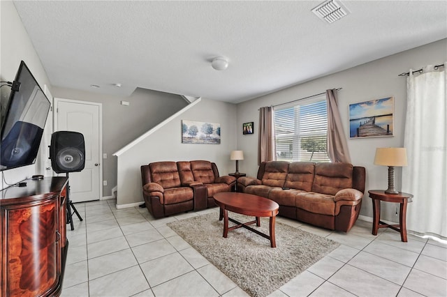 living room featuring light tile patterned flooring and a textured ceiling