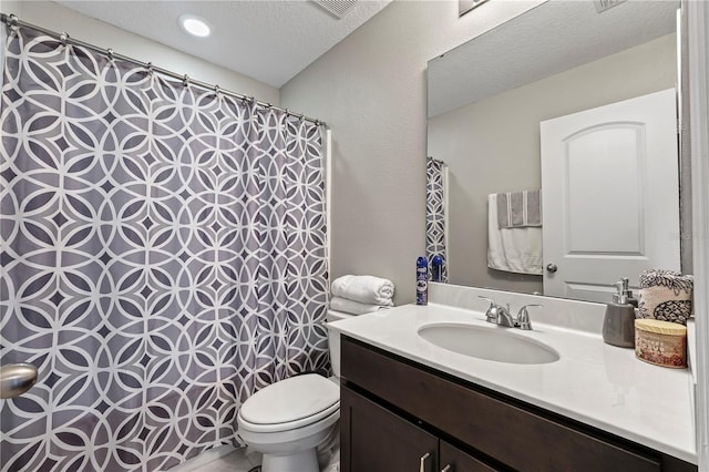 bathroom featuring a textured ceiling, vanity, and toilet