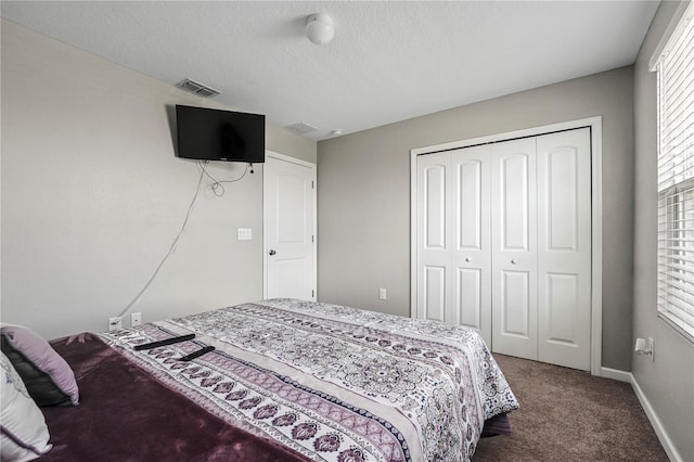 bedroom featuring a closet, a textured ceiling, and carpet floors