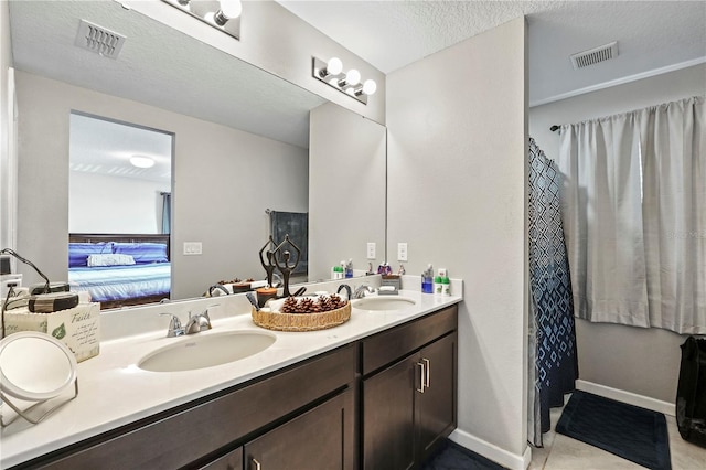 bathroom featuring a textured ceiling, tile patterned floors, and vanity