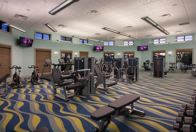 workout area with a towering ceiling and carpet floors