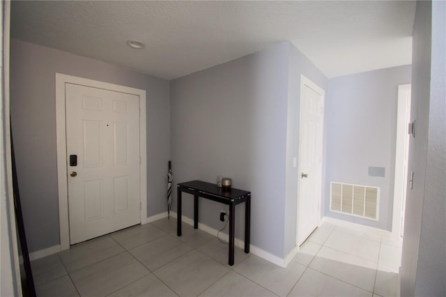 tiled entryway with a textured ceiling