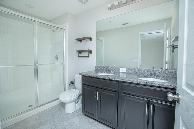 bathroom with vanity, toilet, tile patterned floors, and a shower with shower door