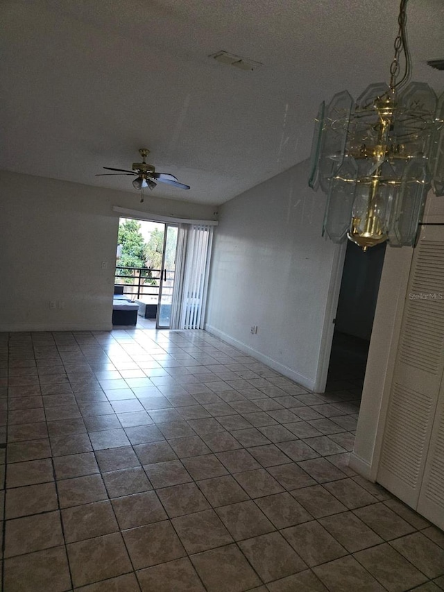 tiled spare room with a textured ceiling and ceiling fan