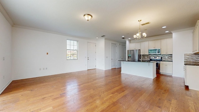 kitchen with hanging light fixtures, a center island, white cabinetry, appliances with stainless steel finishes, and light hardwood / wood-style floors