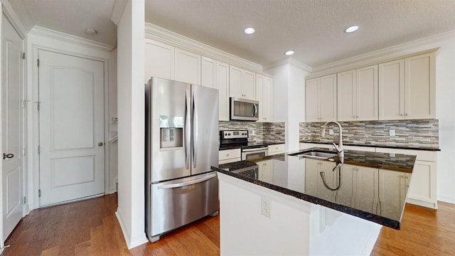 kitchen featuring hardwood / wood-style flooring, stainless steel appliances, sink, and a center island with sink