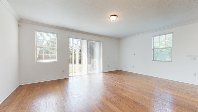 unfurnished room featuring light hardwood / wood-style flooring, a textured ceiling, and crown molding