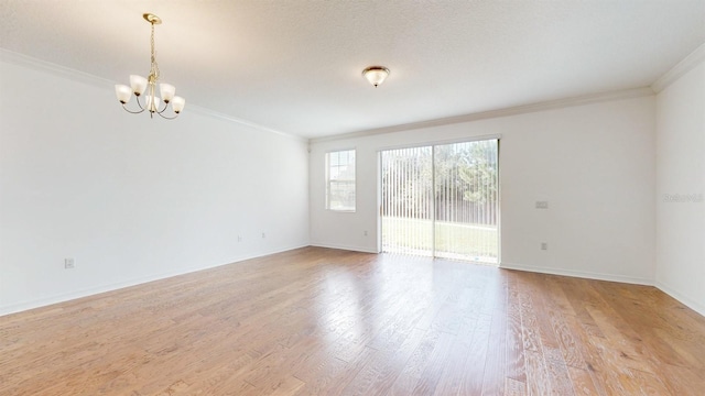 unfurnished room with crown molding, a textured ceiling, light hardwood / wood-style flooring, and an inviting chandelier