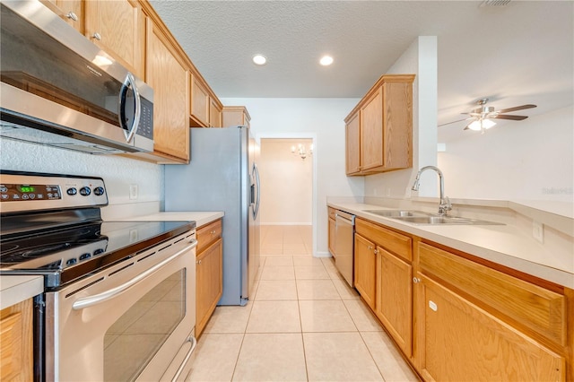 kitchen featuring ceiling fan, light tile patterned floors, sink, a textured ceiling, and appliances with stainless steel finishes