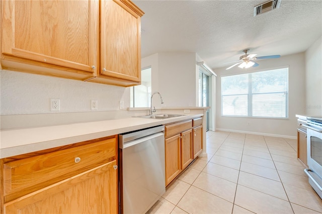 kitchen with ceiling fan, stainless steel dishwasher, sink, light tile patterned floors, and a textured ceiling