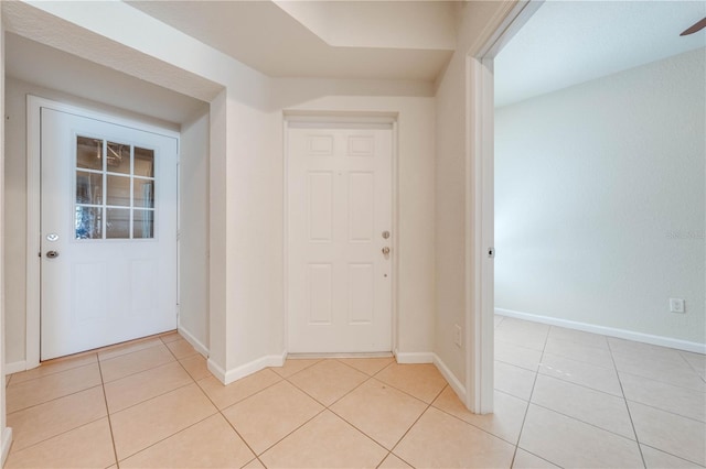 foyer entrance featuring light tile patterned floors and ceiling fan