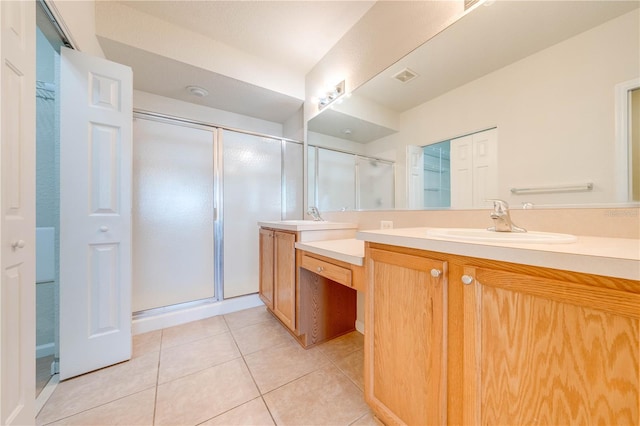 bathroom with tile patterned flooring, a shower with shower door, and vanity