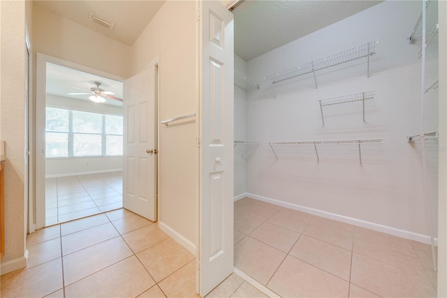 spacious closet featuring light tile patterned floors and ceiling fan