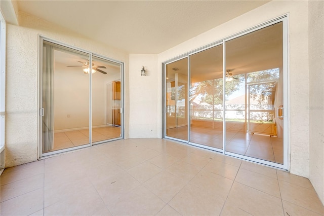 unfurnished sunroom featuring ceiling fan